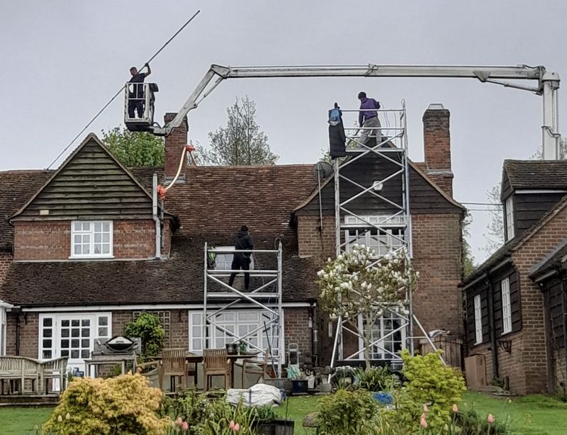 The Moss Cleaners using cherry picker and scaffolding to clean roof safely and professionally in Calne, Wiltshire
